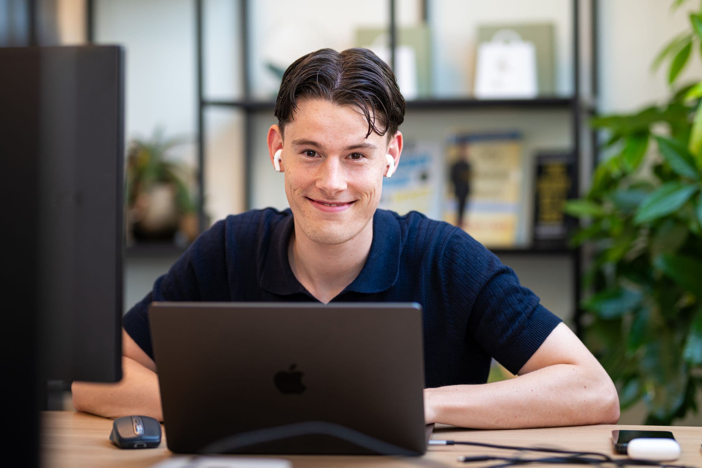 Jonge collega van Accombis aan het werk achter zijn laptop